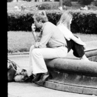 Vintage fountain with people relaxing around it.