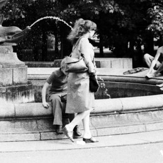 Vintage fountain with people relaxing around it.