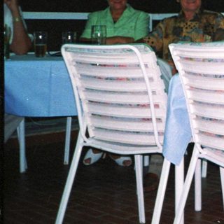 Group of four people dining outdoors at night.