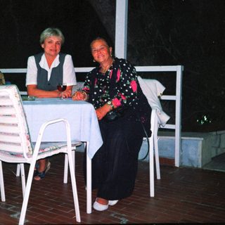Group of four people dining outdoors at night.