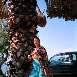 Person riding scooter with large load of logs.