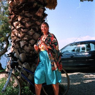 Person riding scooter with large load of logs.