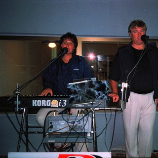 Two musicians performing live on stage.