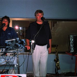 Two musicians performing live on stage.