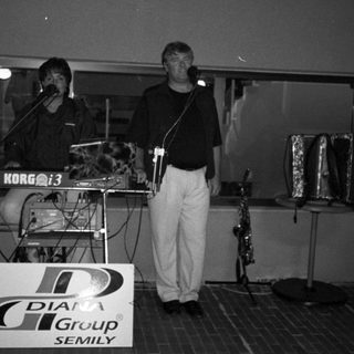 Live band performing indoors with DJia Group Semily sign.