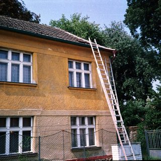 Yellow building with ladder against roof.