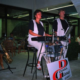 Two musicians performing with keyboards outdoors.