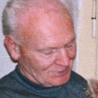 Two people holding small dogs indoors.