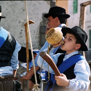 Traditional folk musicians playing bagpipes outdoors.