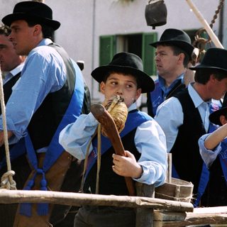 Traditional horse-drawn carriage with passengers in regional attire.