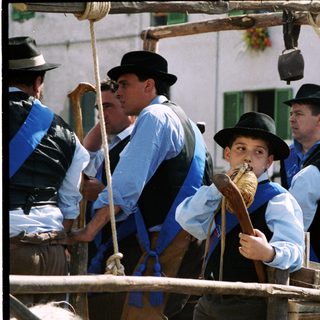 Traditional horse-drawn carriage with passengers in regional attire.