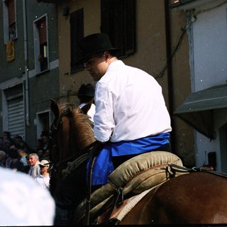 Man in traditional attire riding horse during parade.
