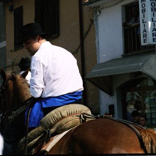Man in traditional attire riding horse during parade.