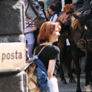 Traditional horseback parade with riders waving.