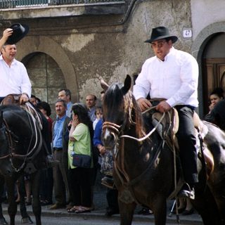 Traditional horseback parade with riders waving.