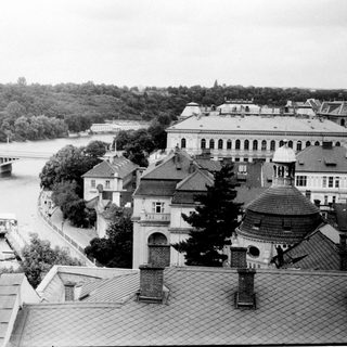 Historic European cityscape by river with bridges.