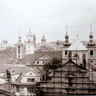 Historic European cityscape with churches and scaffolding.