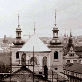 Historic European cityscape with churches and scaffolding.