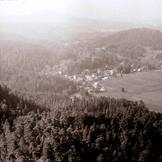 Rural village nestled in forested valley.