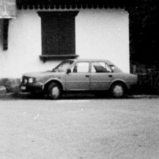 Charming single-story house with gabled roof, parked car.