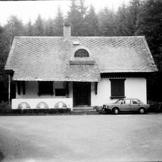 Charming single-story house with gabled roof, parked car.