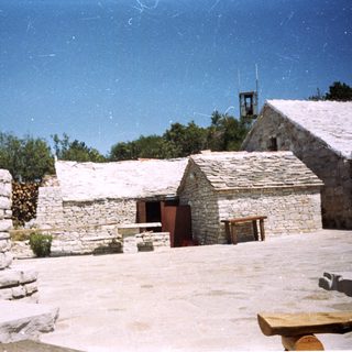 Rustic stone buildings with traditional outdoor altar.