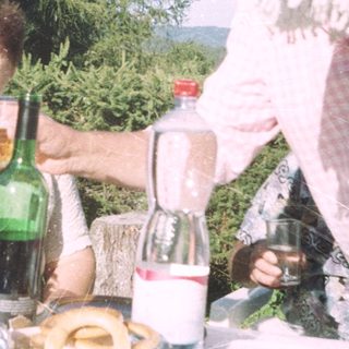 People enjoying drinks outdoors at a picnic.