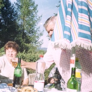 People enjoying drinks outdoors at a picnic.