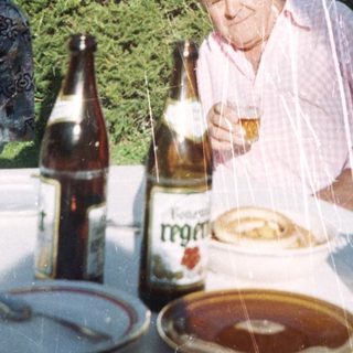 Man enjoying meal outdoors with beer.