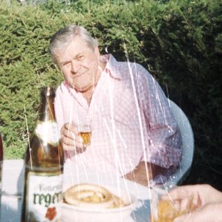 Man enjoying meal outdoors with beer.