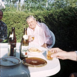 Man enjoying meal outdoors with beer.
