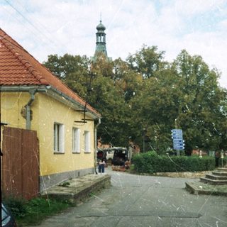 Quaint village street with historic church tower.