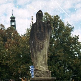 Statue on pedestal in urban square.