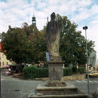 Statue on pedestal in urban square.