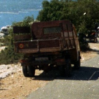 Scenic coastal road with ocean view and truck.