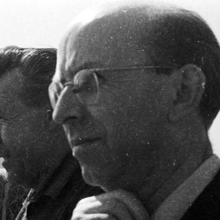 Three men seated outdoors in vintage attire.