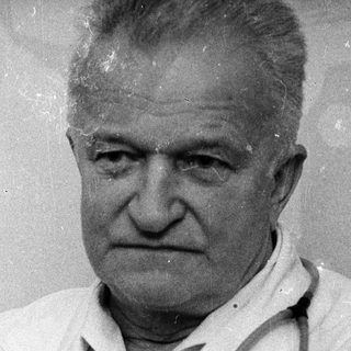 Old man wearing doctor's coat with stethoscope.