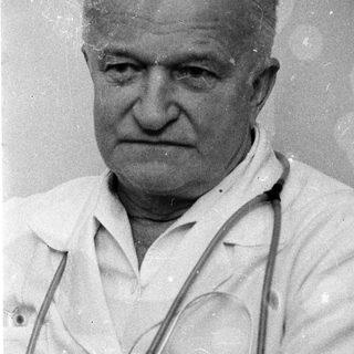 Old man wearing doctor's coat with stethoscope.