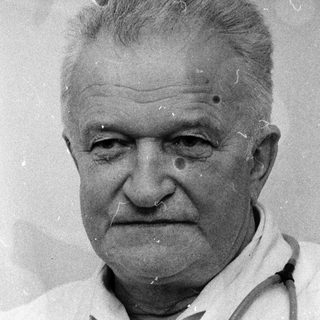 Older man in white coat with stethoscope.
