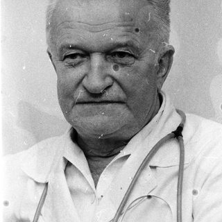 Older man in white coat with stethoscope.