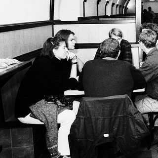 Underground café with patrons dining and staff serving.