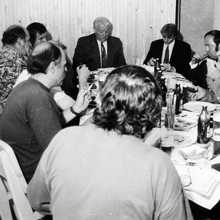 Business meeting or formal gathering with people seated at tables.