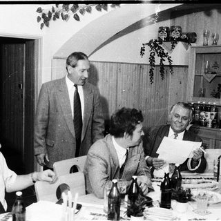 Group of people gathered indoors, likely at a formal dinner or meeting.