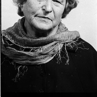 Woman with short gray hair wearing scarf.