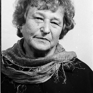Woman with short gray hair wearing scarf.