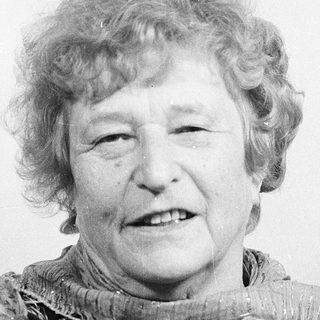 Smiling elderly woman in vintage scarf.