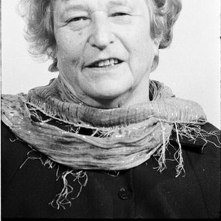 Smiling elderly woman in vintage scarf.
