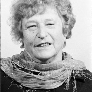Smiling elderly woman in vintage scarf.
