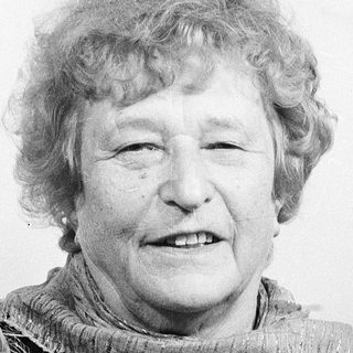 Smiling elderly woman wearing a scarf.