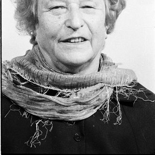 Smiling elderly woman wearing a scarf.